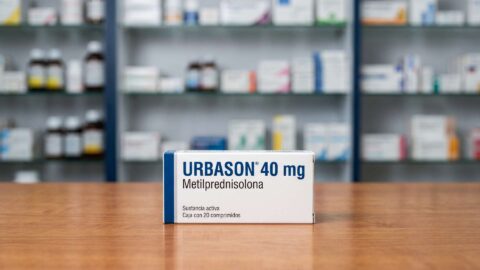 Caja de Urbason 40 mg metilprednisolona en comprimidos sobre mostrador de madera en farmacia