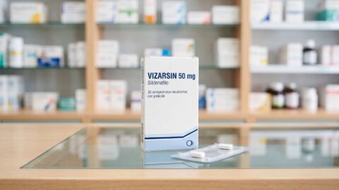 Caja de Vizarsin 50 mg de sildenafilo y blíster con comprimidos sobre el mostrador de una farmacia.