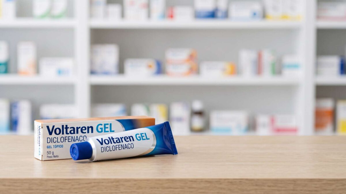 ¿Se puede comprar Voltaren sin receta? 3 Caja y tubo de Voltaren gel con diclofenaco sobre el mostrador de madera de una farmacia
